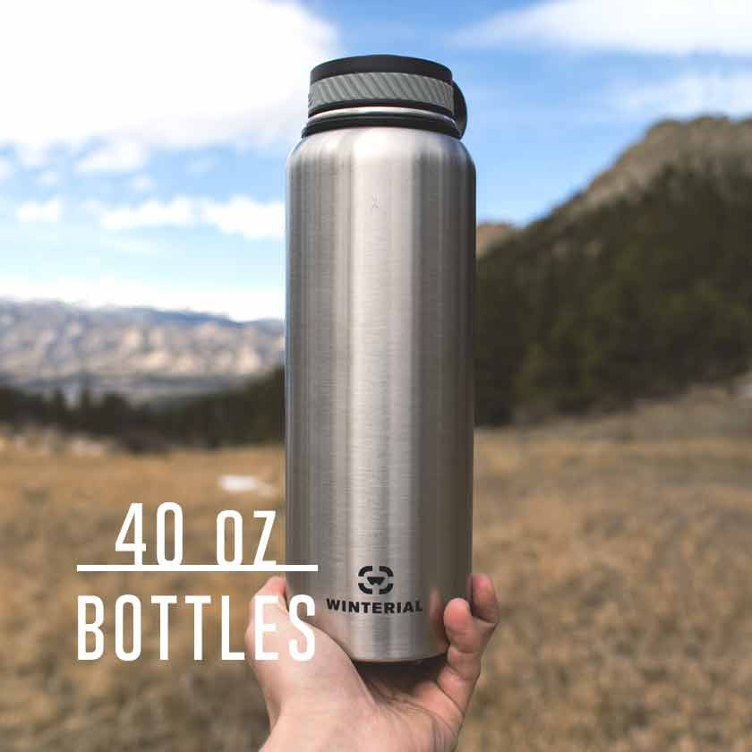 guy holding insulated water bottle up with mountains and valley in the background